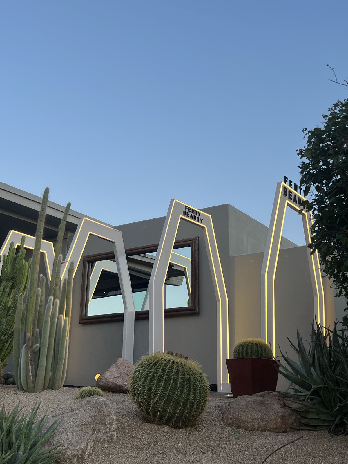 Glowing arch-shaped entry frames among desert landscaping